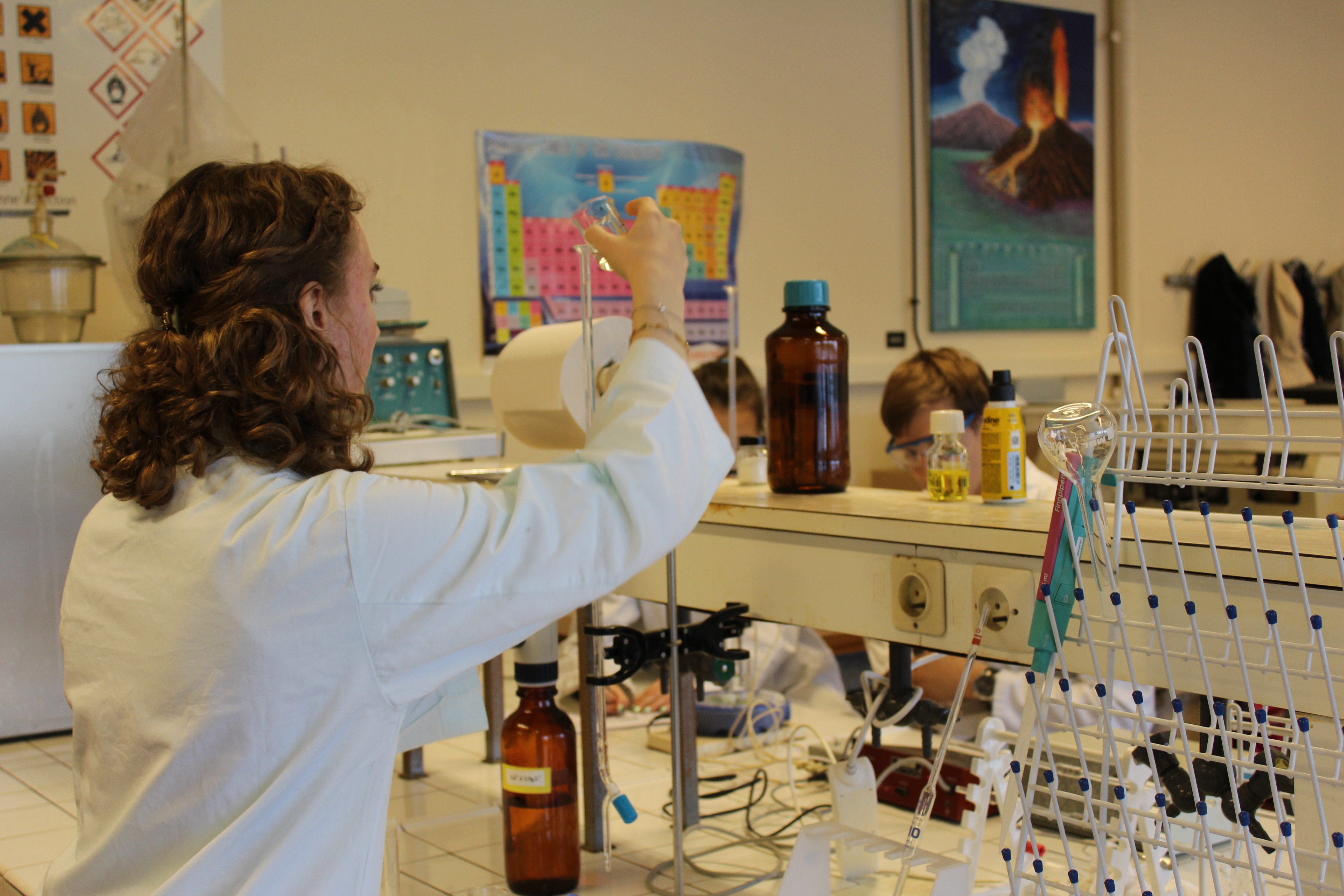 Etudiante en blouse faisant une manipulation de chimie